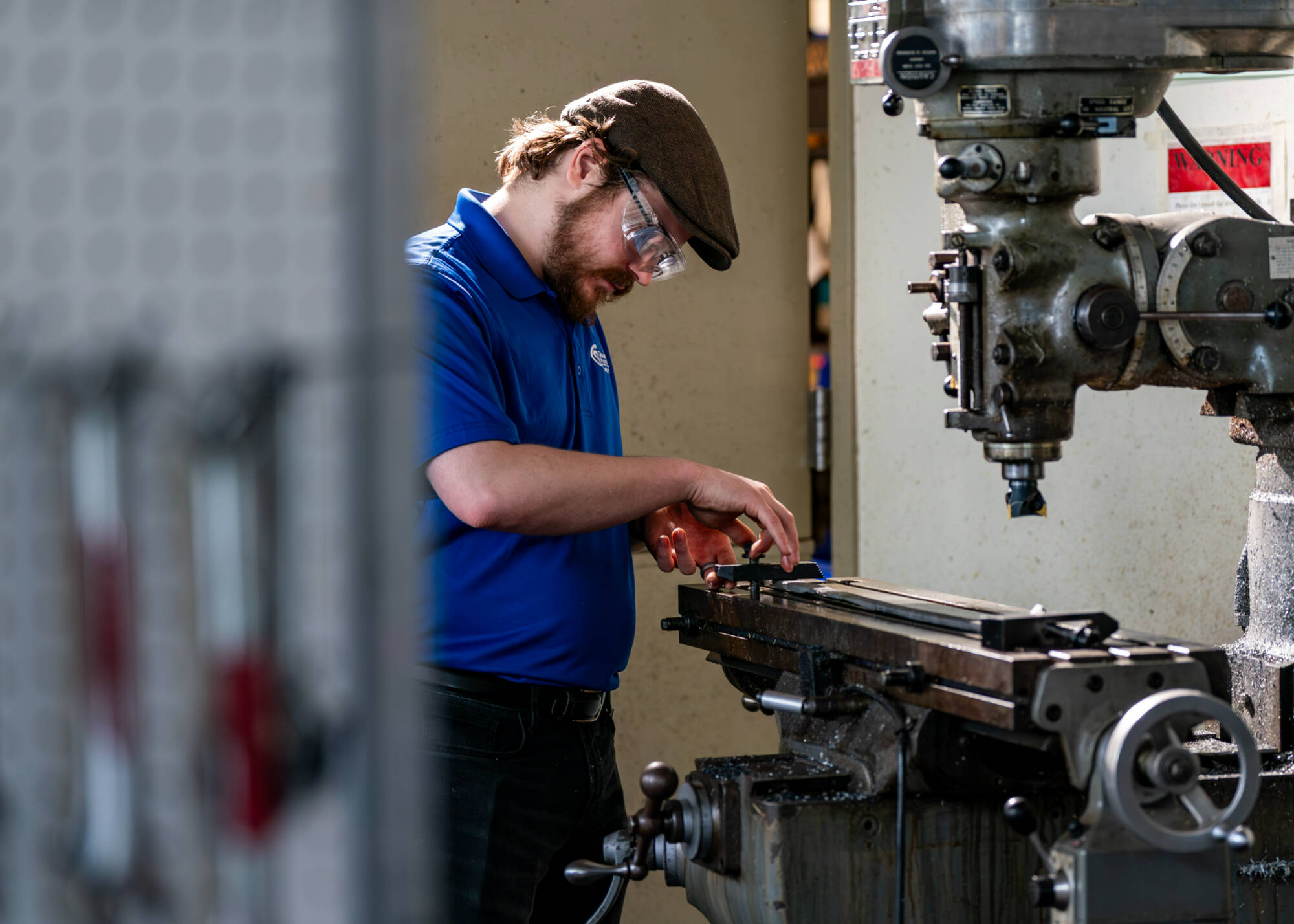 Mechanical engineering majors Rock Phelps prepares to put a sword through a milling process at the Kennedy Hall of Engineering on March 21. Workaholic Productions is producing a video of GVSU students making a sword for the Cast in Steel competition. (...
